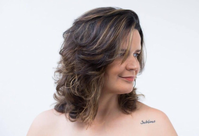 Carol com cabelo médio ondulado em camadas