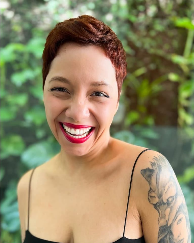 Elisa sorrindo, com corte curto geométrico na cor cobre