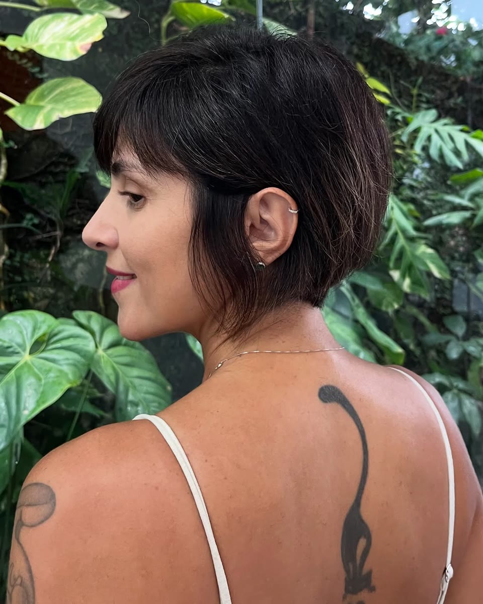 Mariana de costas, sorrindo de lado, com short bob e franja