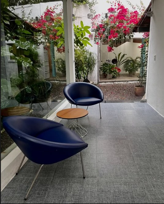 Lounge com poltronas azuis e buganvílias